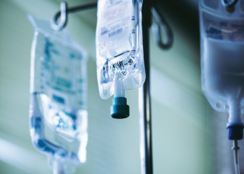 patient IV bags hanging from pole