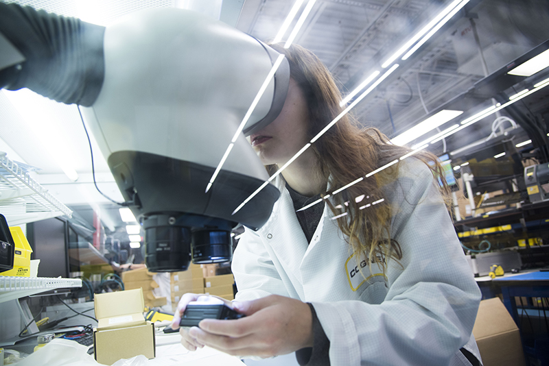 女人穿白大褂工业显微镜下检查样品在实验室环境