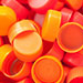 pile of orange colored bottle caps